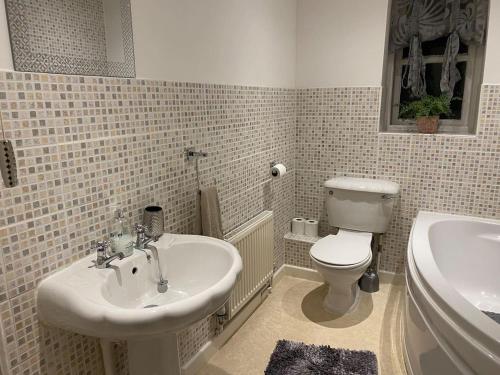 a bathroom with a sink and a toilet and a tub at Beautiful 1 Bed Apartment in the Heart of Ludlow in Ludlow