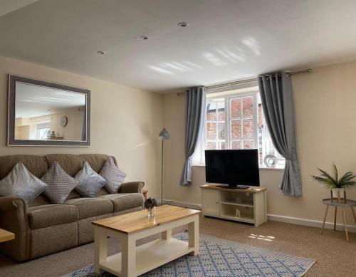 a living room with a couch and a television at Beautiful 1 Bed Apartment in the Heart of Ludlow in Ludlow