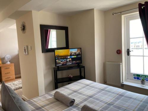 a bedroom with a bed and a flat screen tv at Beautiful 1 Bed Apartment in the Heart of Ludlow in Ludlow