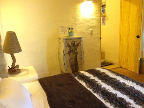 a bedroom with a bed and a lamp on a table at Hotel Posada Primavera in San Cristóbal de Las Casas