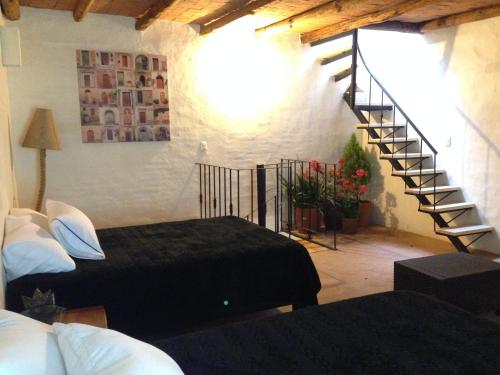 a bedroom with two beds and a spiral staircase at Hotel Posada Primavera in San Cristóbal de Las Casas