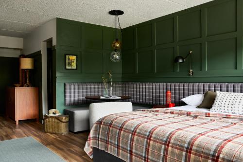 a bedroom with green walls and a bed and a table at Hunter Lodge, a Bluebird by Lark in Hunter