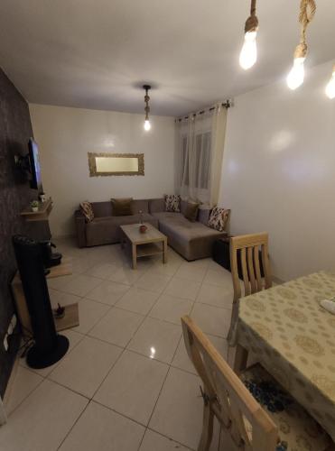 ein Wohnzimmer mit einem Sofa und einem Tisch in der Unterkunft Superbe appartement au rez-de-chaussée avec clim mobile,parking et wifi gratuit in Casablanca