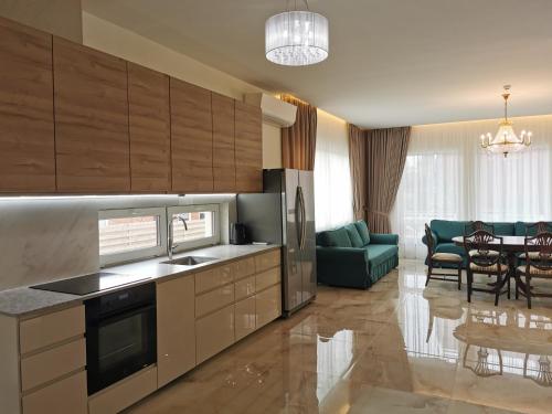 a kitchen with wooden cabinets and a living room at Beach Lounge Luxory Apartments in Klaipėda