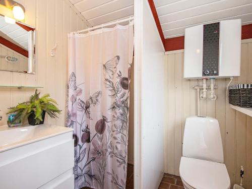 een badkamer met een toilet en een douchegordijn bij Holiday home Hvide Sande CXI in Bjerregård