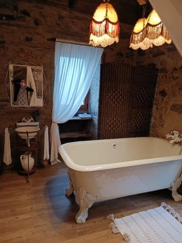 a bath tub in a room with a blue curtain at Casa da Ana - Um refúgio na montanha in Arouca