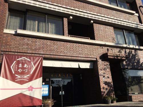 un edificio de ladrillo con un cartel delante en Azumaya Ryokan, en Kioto