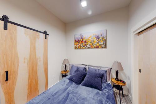 a bedroom with a bed and a painting on the wall at Aspen Crossing in Bozeman