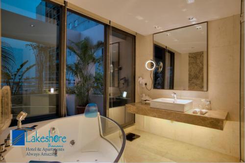 a bathroom with a tub and a sink and a mirror at Lakeshore Banani in Dhaka