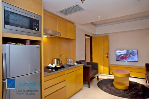 a kitchen with a refrigerator and a living room at Lakeshore Banani in Dhaka
