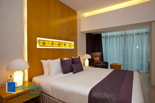 a hotel room with a large bed and a chair at Lakeshore Banani in Dhaka