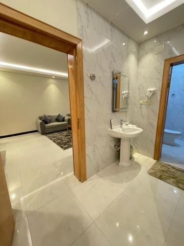 a bathroom with a sink and a couch in a room at فندق اريف in Abha