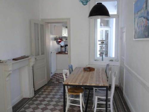 une cuisine avec une table et des chaises dans une pièce dans l'établissement Maison cosy à 200m de la plage, 3 ch, terrasse, WiFi, proche centre, idéale pour famille - FR-1-675-7, à Wimereux