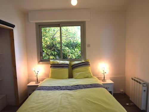 sypialnia z łóżkiem z żółtymi poduszkami i oknem w obiekcie Appartement moderne avec balcon à Évian-les-Bains - FR-1-498-80 w mieście Évian-les-Bains