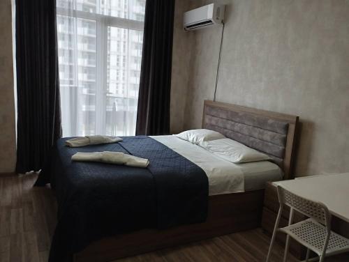 a bedroom with a bed with two towels on it at Apartment in Orbi Sea Tower in Batumi