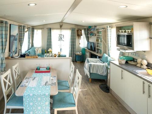 a kitchen and dining room with a table and chairs at Chalet in Oostkapelle near the Beach in Oostkapelle