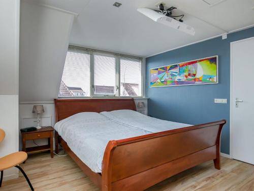 - une chambre avec un lit et un mur bleu dans l'établissement Detached vacation home in Friesland with waterfront views, à Grou