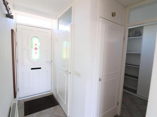 a walk in closet with white cabinets and a window at Detached vacation home in Friesland with waterfront views in Grou