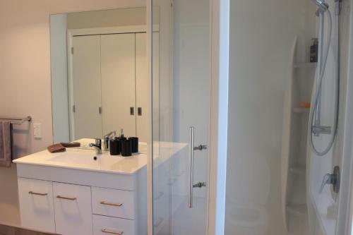 a white bathroom with a sink and a shower at City Centre Escape in Napier