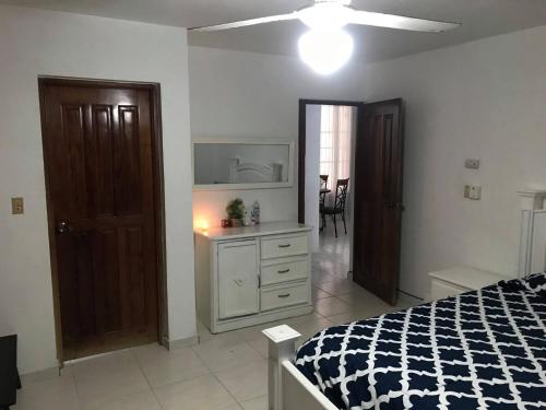 a bedroom with a bed and a dresser at Caribbean Seaview apart Malecon Santo Domingo in Santo Domingo