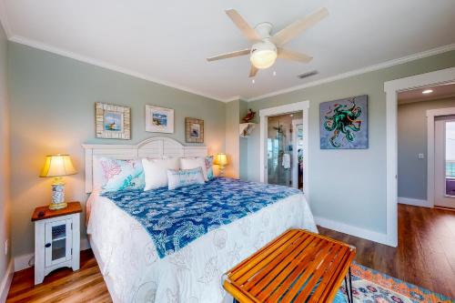 a bedroom with a bed and a ceiling fan at Cornerstone Beachside Cottage in Mexico Beach