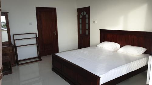 a bedroom with a large bed with white sheets at Rodrigo Building 4 in Boralesgamuwa