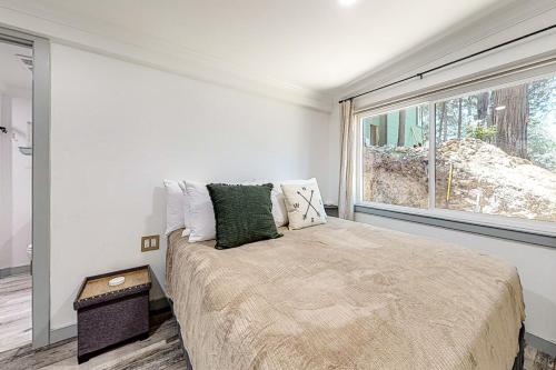Un dormitorio con una cama grande y una ventana. en Top Town Retreat, en Crestline