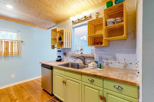 a kitchen with yellow cabinets and a sink at Flip Flop Inn in Dauphin Island