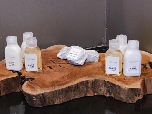 a group of four bottles on a piece of wood at Anukama Resort in Nilaveli