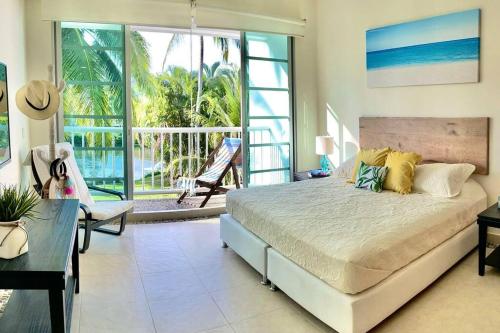 a bedroom with a bed and a view of the ocean at Vista al Lago con balcón en Mayan Lakes in Acapulco