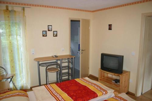 a bedroom with a bed and a tv and a table at Gasthof Zum Stausee in Engelskirchen