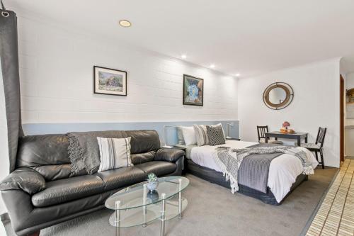 a living room with a couch and a table at Sandbar Motel in Lakes Entrance