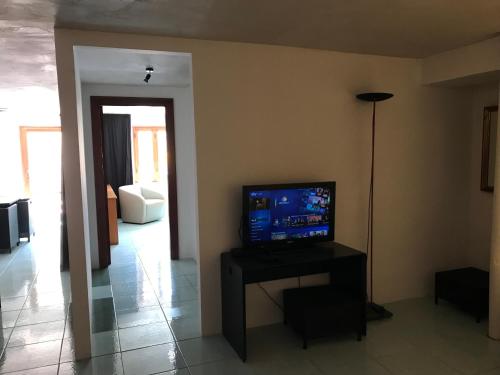 a living room with a television on a table with a lamp at Park House in Mondello
