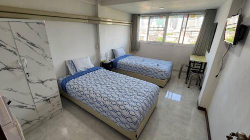 a bedroom with two beds and a television in it at APARTMENT A4 DINDAENG in Bangkok
