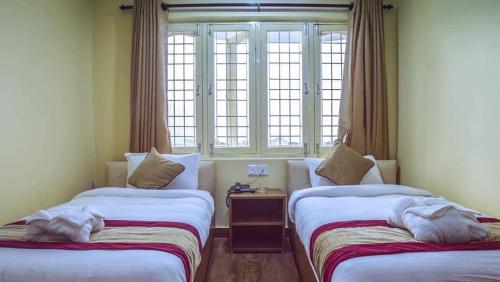 2 camas en una habitación con ventana en Hotel Dream Light, en Pokhara