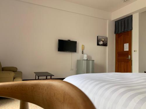 pokój hotelowy z łóżkiem i telewizorem w obiekcie Three-night homes w mieście Jincheng