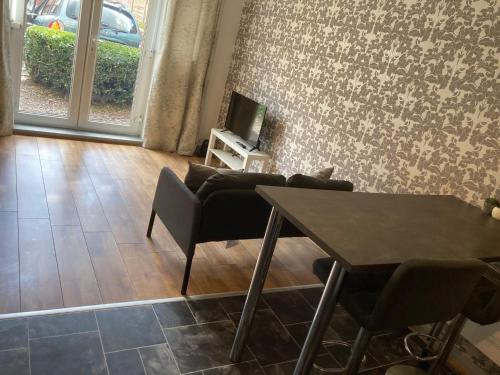 a living room with a table and a couch at 1 Bedroom Apartment - Bedworth Nuneaton Coventry in Attleborough