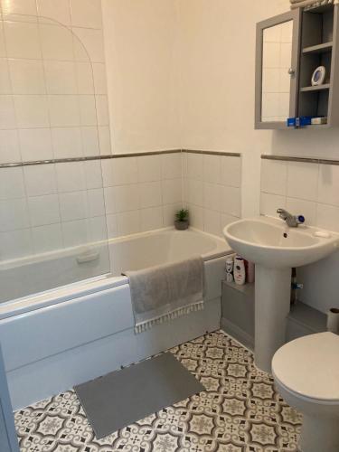 a bathroom with a tub and a sink and a toilet at 1 Bedroom Apartment - Bedworth Nuneaton Coventry in Attleborough