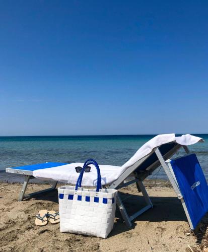 a beach chair and a basket on the beach at SUITEBEACH b&b and resort in Marsala