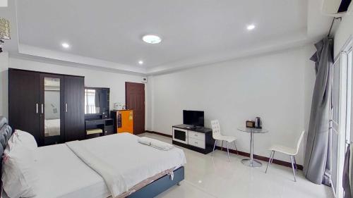 a bedroom with a bed and a table and chairs at Grand Airport Resort in Lat Krabang