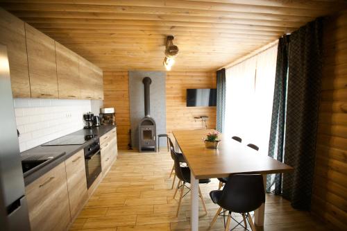 a kitchen with a wooden table and a dining room at Istebna Pełna chata in Istebna