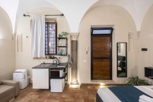 une chambre avec un évier et une cuisine avec une porte dans l'établissement Studio delle Grotte - Campo de’ Fiori, à Rome
