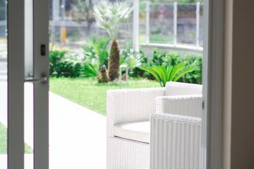 un par de sillas blancas de mimbre en un porche en Luxury House, en Villapiana