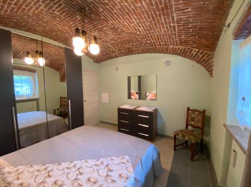 a bedroom with a large bed and a chair at Villa Giulia - Bisalta in Peveragno