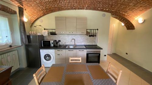 a kitchen with a table and a sink and a stove at Villa Giulia - Bisalta in Peveragno