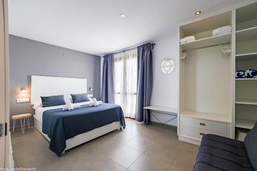 Un dormitorio con una cama azul y blanca y una ventana. en MIMAR ALTEA REMEDI urban, en Altea