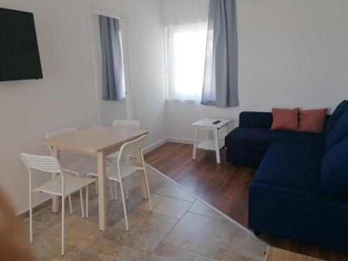 - un salon avec une table et un canapé bleu dans l'établissement Sóstói Strand Apartmanház, à Siófok