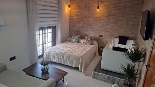 a bedroom with a bed and a couch in a room at ESTUDIO Jacuzzi SOL De JEREZ in Jerez de la Frontera