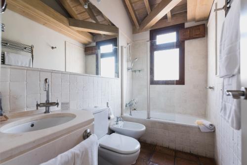 uma casa de banho com um WC, um lavatório e uma banheira em Palacio De Los Navas em Granada
