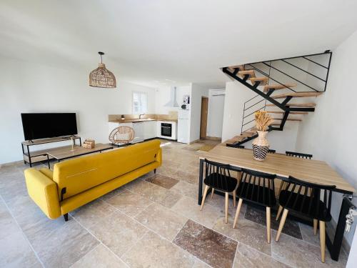 a living room with a yellow couch and a table at Résidence L’Oiseau des Sables in Saintes-Maries-de-la-Mer